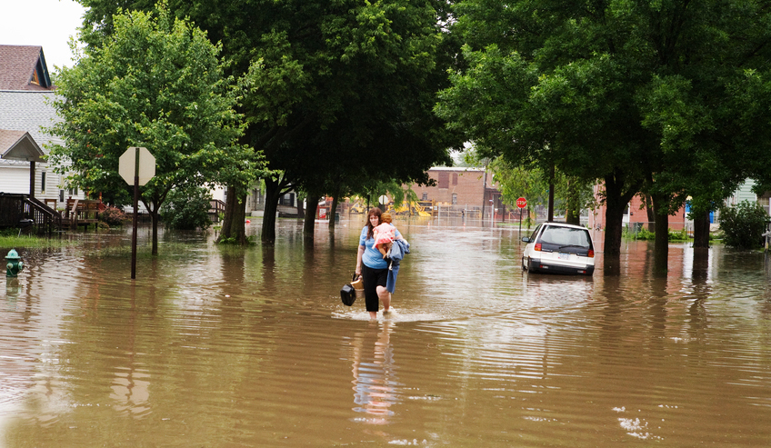A woman carries what belongings she could save during the 2008 flood of Cedar Rapids, IA. The region experienced major flooding again in September of 2016.